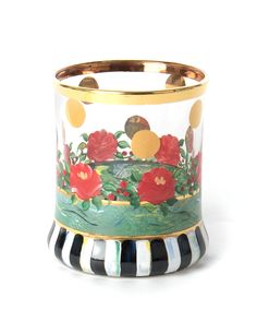 a glass vase with flowers painted on the side and gold trimming around the bottom