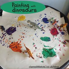 a tray with paint and dinosaurs on it