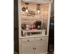 a white cabinet with some lights on it and coffee maker in the corner next to it