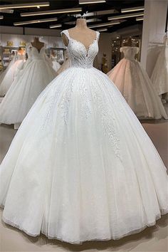 a white ball gown on display in a store with lots of other dresses behind it