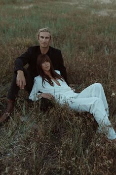 a man and woman laying in the grass