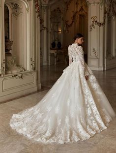 a woman in a white wedding dress is standing on the floor with her back to the camera