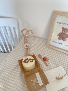 a teddy bear cake in a box on a table next to a sign and other items