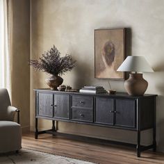 a living room with a couch, table and lamp on it's sideboard