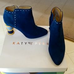 a pair of blue suede boots sitting on top of a white box with the word kayty per