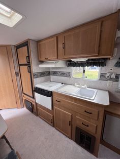 a kitchen area with sink, stove and cabinets in an rv or camper trailer