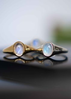 Our Moonstone Signet Ring is handmade with genuine natural medium size Rainbow Moonstone in an oval shape in 925 sterling silver & 18k Gold Vermeil. An everyday classic piece of jewelry with a touch of modern, you will never regret investing in. Every stone has a subtle blue flash on its smooth surface. Securely set in our custom made sleek and minimalist bezel setting. D E T A I L S * Materials - 925 sterling silver, genuine natural moonstone, 18k gold vermeil (thick gold plating over sterling Minimalist Polished Moonstone Ring For Anniversary, Classic Gold Moonstone Ring, Polished Moonstone Wedding Ring, Wedding Moonstone Ring With Polished Finish, Oval Moonstone Ring In White Gold, Silver Oval Dainty Signet Ring, Minimalist Oval Moonstone Ring, Classic Moonstone Rings With Gemstone, Classic Moonstone Gemstone Rings