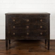 an old chest of drawers sitting on top of a hard wood floor