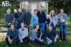 a group of people posing for a photo in front of a small shed and trees