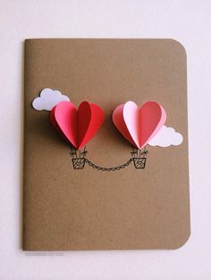 two paper hearts are attached to a card