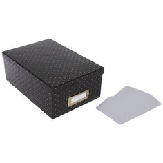 a black box with white polka dots on it and a piece of paper next to it