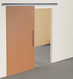 an open door in the middle of a room with white walls and grey flooring