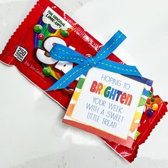 two candy bars tied to each other with a blue ribbon around them on a white surface