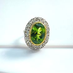 This is a truly beautiful ring, from the size and quality of peridot it features to the exquisite Florentine inspired craftsmanship. The large oval peridot is clear and crystalline, with bright, "Granny Smith" apple green color, set in 18k yellow gold to highlight its beauty. If August is your birth month, peridot is your birthstone. Sparkling round brilliant cut diamonds further adorn the white gold portion of the ring which has been intricately pierced, creating an elegant, regal appearance. H Apple Green Color, Granny Smith Apple, Granny Smith Apples, Granny Smith, Domed Ring, Apple Green, Birth Month, Beautiful Ring, Round Brilliant Cut Diamond