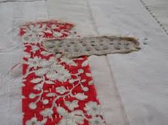 a piece of fabric with white flowers on it is laying on top of a table cloth