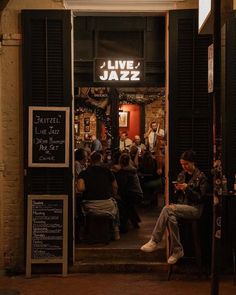 people sitting at tables in front of a jazz bar