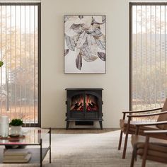 a living room with a fire place next to a painting on the wall and chairs