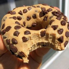 a half eaten chocolate chip doughnut in someone's hand