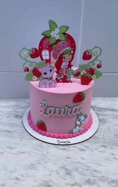 a pink cake decorated with strawberries and strawberrys