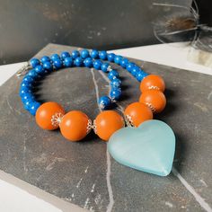 - Blue Puffy Heart Pendant Choker: A bold statement piece featuring a large, soft-textured heart pendant, ideal for adding a touch of romance to any outfit. - Orange Huge Bead Jewelry: Vibrant and eye-catching, these oversized beads make a daring statement, perfect for those who love to stand out. - Maximalist Jewelry: Embracing the 'more is more' philosophy, this style is for the bold and the fearless, featuring large, colorful pieces that command attention. - Blue Jasper Statement Necklace: Kn Blue Heart Beads Heart-shaped Necklace, Blue Heart Beads Heart Necklace, Blue Heart Beads Necklace In Heart Shape, Blue Heart-shaped Necklaces With Heart Beads, Blue Heart Necklace With Heart Beads Pendant, Blue Heart Pendant Necklace With Heart Beads, Blue Heart Necklace With Heart Beads, Blue Heart Beaded Necklaces, Blue Heart Beads Necklace