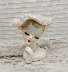 a ceramic figurine with a hat on it's head sitting on a counter