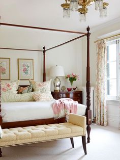 a bedroom with a four poster bed and chandelier