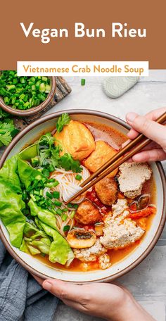 a person holding chopsticks over a bowl of vegan bun rieuu