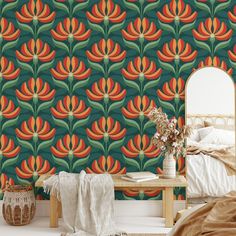 a bed room with a neatly made bed and a wall paper that has orange flowers on it