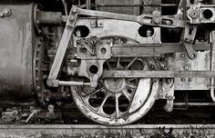 black and white photograph of an old train engine with rust on it's wheels