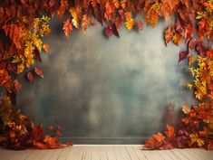 an empty room with autumn leaves on the wall and wood flooring in front of it