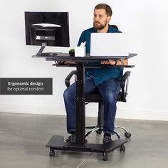 a man sitting at a desk using a laptop computer