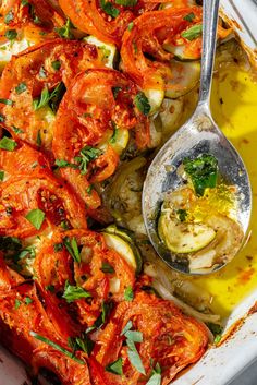 a white dish filled with lots of food and a spoon on top of the dish