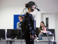 a woman in black is standing with her back turned to the camera, and she has long hair on top of her head