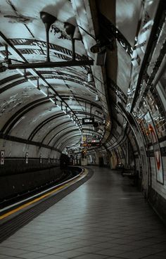 an empty subway station with its lights on and no people in the tunnel or train