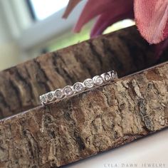 a diamond ring sitting on top of a piece of wood