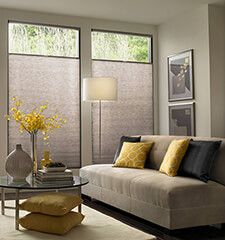 a living room filled with furniture and windows covered in shades of grey, yellow and white