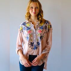 A Field Of Embroidered Flowers Enlivens This Easy, Effortless Blouse From Johnny Was. Our Johnny Was Embroidered Odette Blouse, $268 Is A Feminine Top With A 5-Button Placket And Pairs Perfectly With Your Favorite Denim And Is Fit For Any Occasion. With Its Trendy And Sophisticated Embroidered Design And Chic Pops Of Color, This Top Can Effortlessly Elevate Any Outfit Or Special Occasion. Pair With Simple Denim For A Timeless Boho Look! Pink V-neck Top With Floral Embroidery, Intricate Embroidery V-neck Tops, Pink V-neck Embroidered Top For Spring, Pink Embroidered Feminine Blouse, Spring Embroidered Blouse, Pink Feminine Embroidered Blouse, Spring Embroidered Blouse For Daywear, Pink Blouse With Embroidered Neckline For Spring, Embroidered Blouse For Spring Daywear