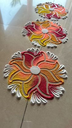 three flower designs are on the floor with white and red colors, one is yellow