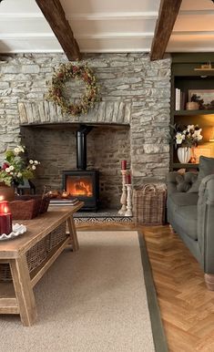 a living room filled with furniture and a fire place next to a stone wall covered in wreaths