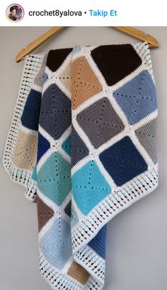 a crocheted blanket hanging on a clothes hanger