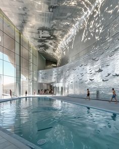 an indoor swimming pool with people walking around it