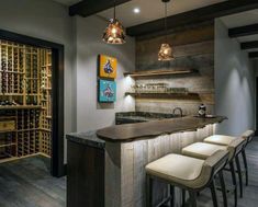 a bar with stools in front of it next to a wine rack