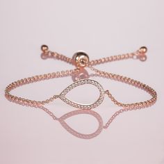 Features * Dainty chain bracelet for women, with AAA cubic zirconia encrusted pear-shaped motif. Rose gold bracelet for women with a 19mm by 12.5mm halo motif in a pear shape. * Chain bracelet with adjustable sizing through a stylish bead fastening featuring the NAMANA logo * Rose gold bracelet for women made from 18ct rose gold-plated brass * Nickel-free and lead-free high-quality fashion jewellery by NAMANA  * Presented in a specially designed jewellery box, creating a thoughtful gift for a tr Elegant Rose Gold Cubic Zirconia Crystal Bracelet, Elegant Rose Gold Crystal Bracelets, Cubic Zirconia Tennis Bracelet With Adjustable Chain, Rose Gold Cubic Zirconia Tennis Bracelet Gift, Adjustable Chain Rose Gold Diamond Bracelet, Rose Gold Jubilee Bracelet With Cubic Zirconia, Formal Rose Gold Bracelet With Cubic Zirconia, Rose Gold Cubic Zirconia Jubilee Bracelet, Rose Gold Diamond Bracelet With Adjustable Chain