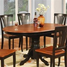 a dining room table with four chairs and a vase on top of it in front of a window