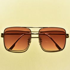 These 1970s vintage style sunglasses feature an oversized square lens, are outlined with a chic gold rim, provide UV 400 protection and comes in three translucent colors. Each sold separately. Dimensions: Length: 6 inches Lens diameter: 2.2 inches Retro Square Frame Aviator Sunglasses For Summer, Trendy Gold Square Frame Aviator Sunglasses, Brown Metal Frame Shield Sunglasses For Summer, Retro Shield Sunglasses With Square Frame And Tinted Lenses, Retro Gold Aviator Sunglasses With Gradient Lenses, Gold Retro Aviator Sunglasses With Gradient Lenses, Gold Retro Sunglasses For Summer, Retro Gold Sunglasses For Summer, Retro Gold Rectangular Sunglasses