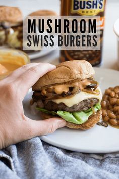 mushroom swiss burgers on a white plate with beans and mustard in the background text reads mushroom swiss burgers