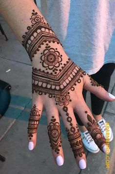 a woman's hand with henna tattoos on it