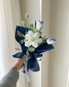 a person holding a bouquet of flowers in their hand