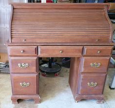 an old wooden desk with drawers and knobs on the top, sitting in a garage