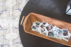 a wooden tray filled with photos on top of a table